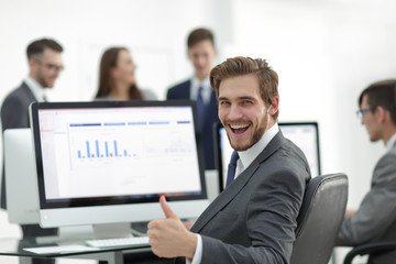 Successful business man with a thumb up in the office