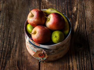 Still life of apples in a vintage box on dark wood table
