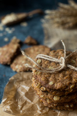 Homemade oatmeal fitness cookies on wooden board and dark stone talbe. Healthy lifestyle, vegan breakfast concept, selective focus