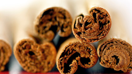Cinnamon stick quills cooking spices macro closeup. on vintage red wood table, selective focus.