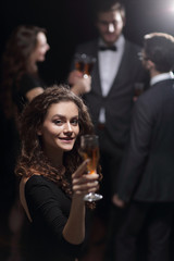 Plakat stylish young woman raising a glass of champagne