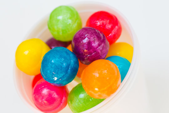 Rainbow design of sweet colorful lollipops against white background 