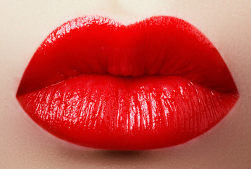 Obraz premium Cosmetics, makeup and trends. Bright lipstick on lips. Closeup of beauty female mouth with red lip makeup. Beautiful part of female face. Perfect clean skin