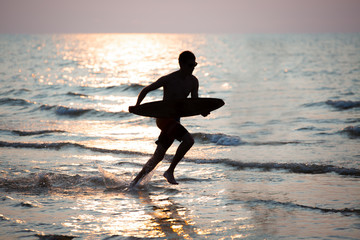 Silhouette of man surfing at sunset