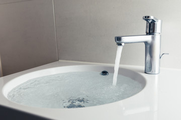 faucet with flowing water in wash sink