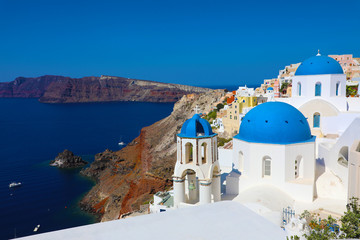 Fototapeta na wymiar Stunning panoramic view of Santorini island with white houses and blue domes on famous Greek resort Oia, Greece, Europe. Traveling concept background. 