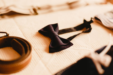 Clothing accessories for a child, suspenders, shoes and belt.