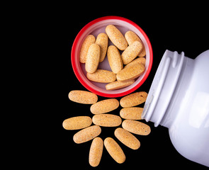 oval brown pills in a red cap on a dark blue background