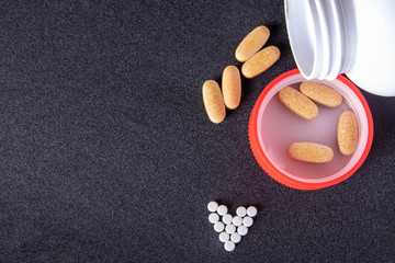 oval brown pills in a red cap on a dark blue background