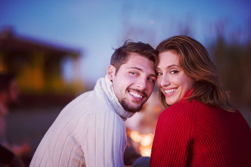 Couple enjoying with friends at sunset on the beach