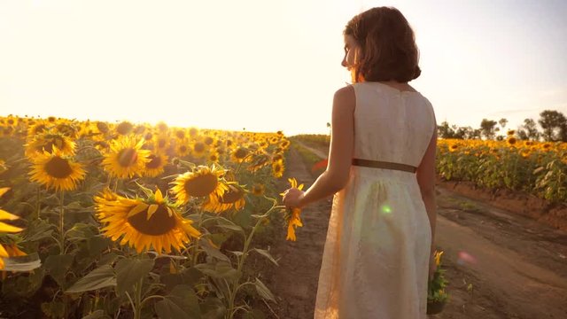little girl running across the field with sunflowers at sunset. slow motion video. girl runner in the field at sunset sunflowers. girl lifestyle sunlight runs the concept of sunflowers