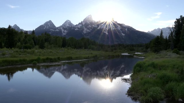 sun setting behind grand teton from schwabachers landing in grand teton national park in the united states