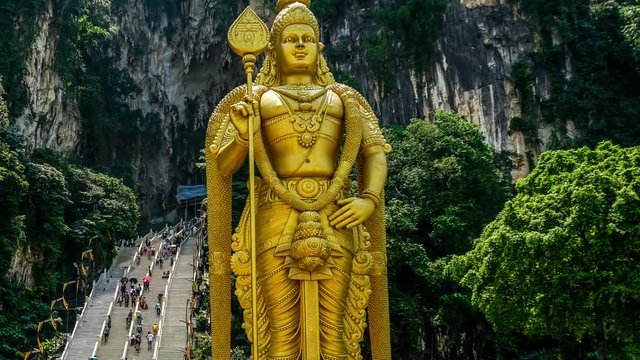 Lord Murugan Hindu Deity Statue at Batu Caves and tourist flow in Malaysia Time Lapse 4K