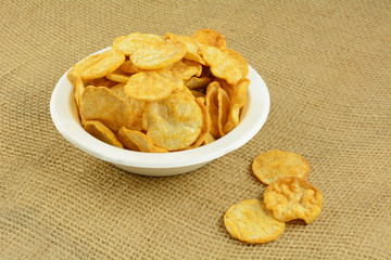 Healthy alternative of crispy healthy hummus and basil chips in eco-friendly disposable white fiber bowl