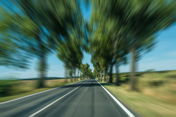 drivers view of car driving fast on country road freeway - motion blur