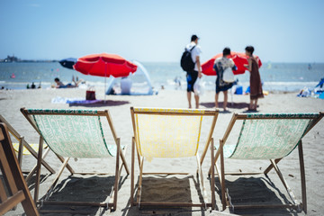 Three beach chairs on the beach and the sea