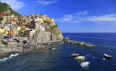 Colorful village of Manarola with fisher boats on the foreground, Cinque Terre, Italy