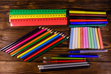 Different school stationeries on a dark wooden table