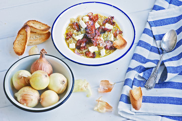 French onion soup with bacon and camembert in a white metal plate