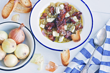 French onion soup with bacon and camembert in a white metal plate
