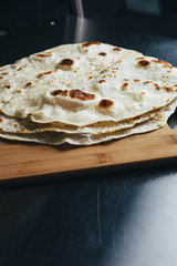 Tortilla Shells On Wooden Plank On Brushed Metal Counter