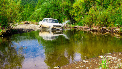 Fototapeta na wymiar The car is going through the river