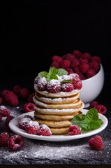 Pancakes with raspberries on black backgound