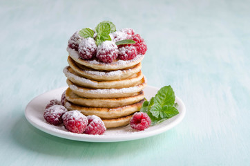 Pancakes with raspberries on blue table