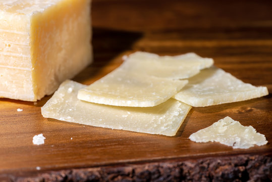 close up portion and slaced of fresh parmesan cheese on wooden background