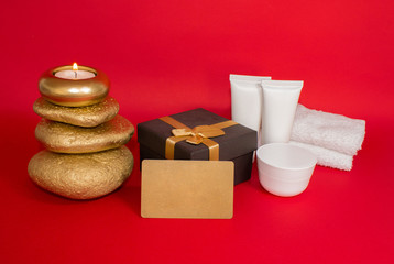 Gift set, Candle, stones, spa cosmetics, gift box and gift card. On a red background.