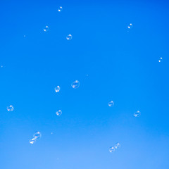 Soap bubbles in flight against the blue sky