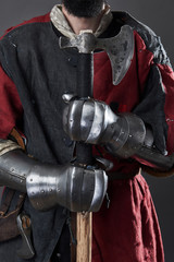 Medieval knight on grey background. Portrait of brutal dirty face warrior with chain mail armour...