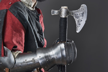 Medieval knight on grey background. Portrait of brutal dirty face warrior with chain mail armour...