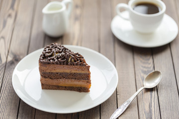 Dessert souffle with chocolate sauce and nuts on a white plate, on a wooden table.