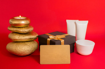 Gift set, Candle, stones, spa cosmetics, gift box and gift card. On a red background.