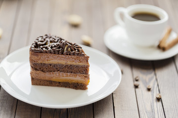 Dessert souffle with chocolate sauce and nuts on a white plate, on a wooden table.
