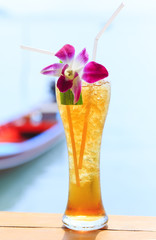 glass of ice tea on tropical background