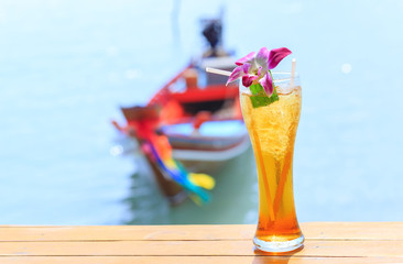 glass of ice tea on tropical background