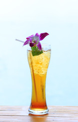 glass of ice tea on tropical background