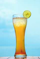glass of ice tea on tropical background