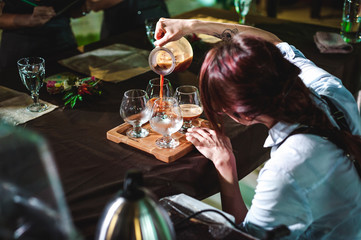 women's hands professionally barista pour the prepared drink into glass cups. championship among...