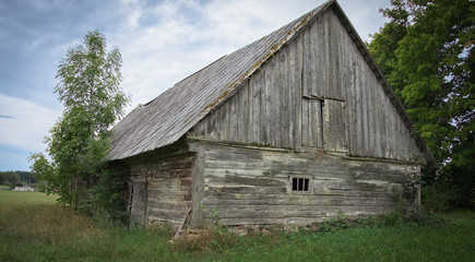 An old abandoned wooden shed with a roof of slate in the village.