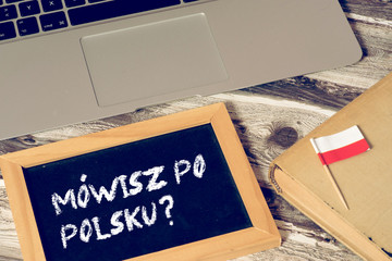 Ein Computer, Flagge von Polen und eine Kreidetafel mit der Frage Sprechen Sie polnisch