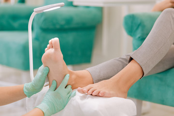 Fototapeta premium Feet massage. Prosperous businesswoman feeling relaxed while visiting beauty salon for feet massage
