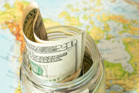 Die Landkarte von USA und ein Einmachglas mit Dollar Geldscheinen