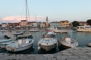 Fazana, Croatia - July 28, 2018: View of the harbour of Fazana with the market and the church in the background in the evening sun, Croatia.