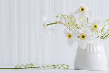 spring flowers in vase on white wooden background