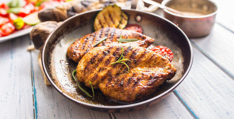 Grilled chicken breast in old frying pan.