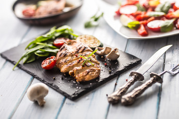 Grilled chicken breast on slate board.