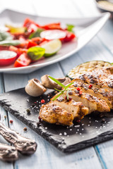 Grilled chicken breast on slate board.